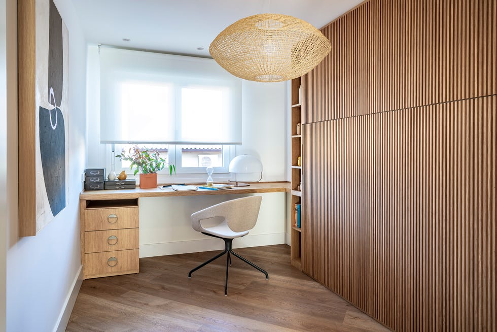habitación con escritorio y cama abatible escondida en revestimiento de palillería