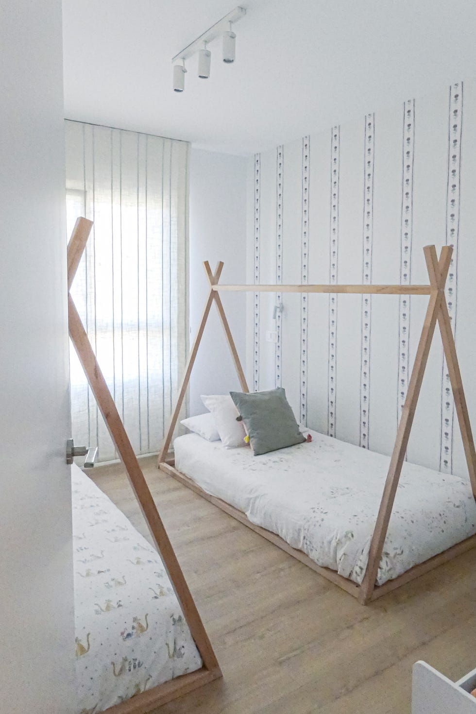 habitación infantil con camas de madera con estructura de tipi