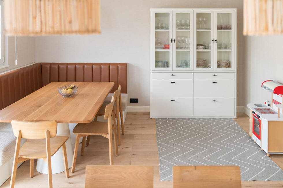 office con banco tapizado en piel, mesa de madera y vitrina blanca
