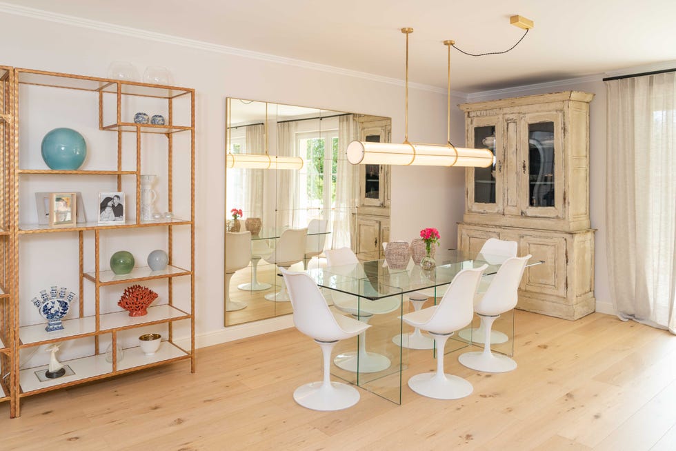 comedor con mesa de cristal, sillas tulip y vitrina clásica