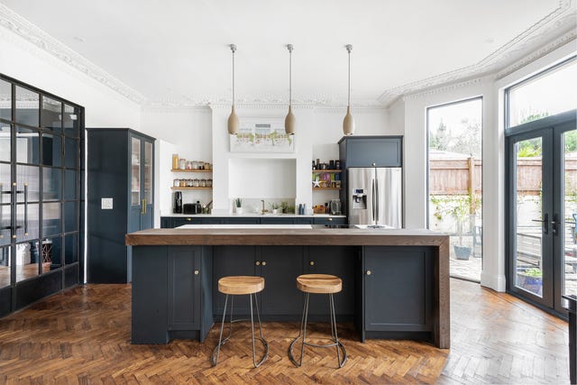 cocina abierta con isla central y suelo de parquet en espiga