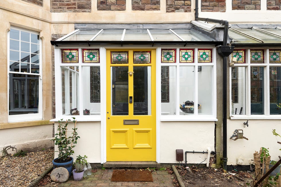 mudroom con puerta pintada en amarillo y vidrieras decorativas