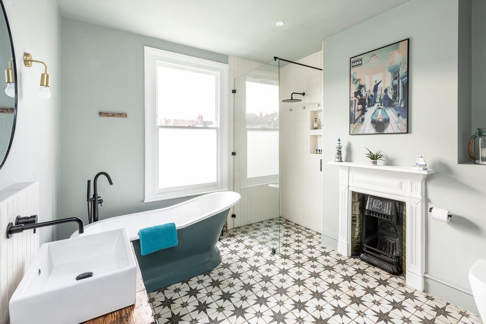 baño vintage con chimenea, bañera exenta clásica y suelo de baldosas hidráulicas