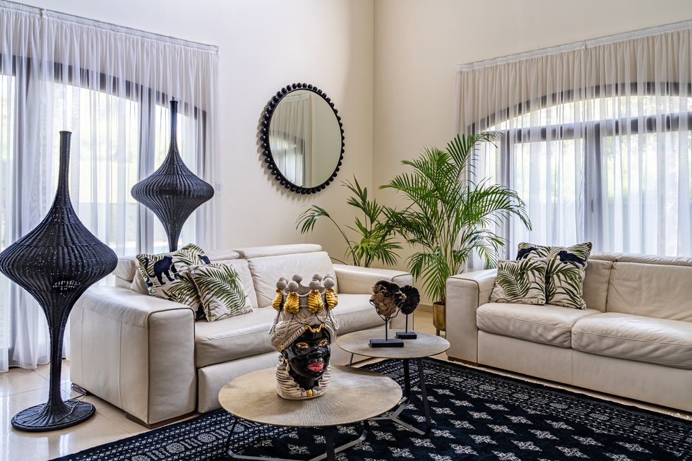 salón con dos sofás beiges, plantas de interior y elementos exóticos