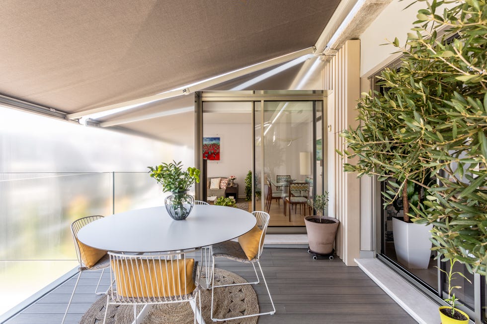terraza con toldo y comedor de diseño moderno con mesa redonda