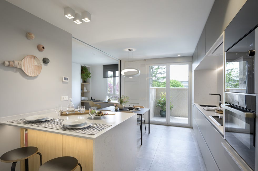 cocina moderna con office, isla central y cerramiento de vidrio