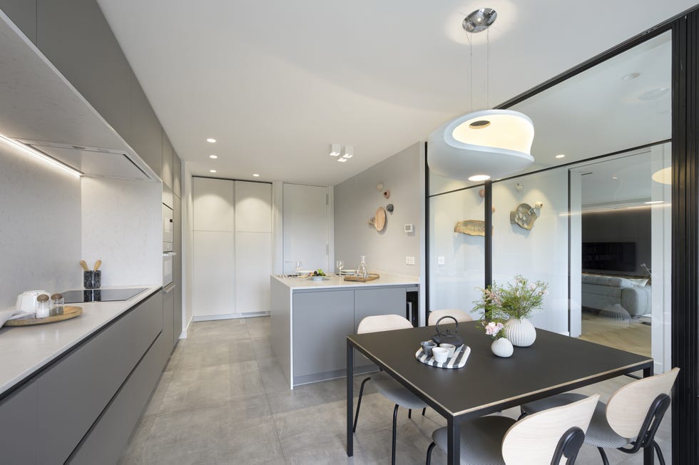 cocina moderna con office, isla central y cerramiento de vidrio
