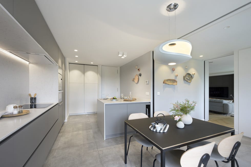 cocina moderna con office, isla central y cerramiento de vidrio