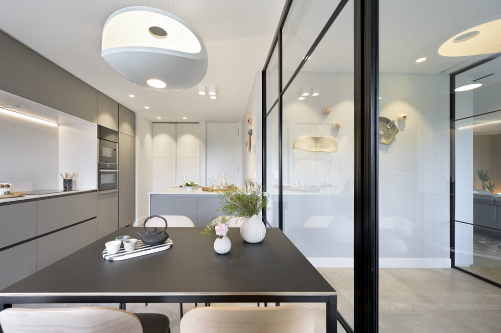 cocina moderna con office, isla central y cerramiento de vidrio
