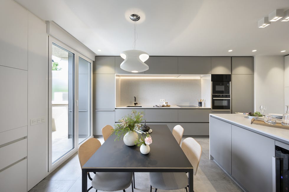 cocina moderna con isla central y office diseñada en blanco y gris
