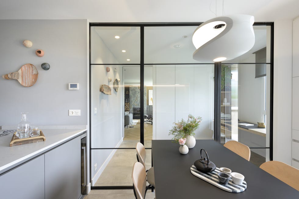 cocina moderna con office, isla central y cerramiento de vidrio