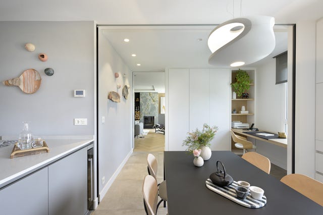 cocina moderna con office, isla central y cerramiento de vidrio
