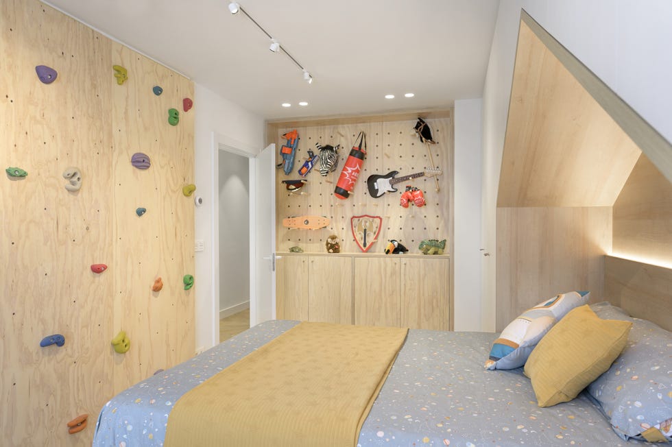 habitación infantil con rocódromo en la pared