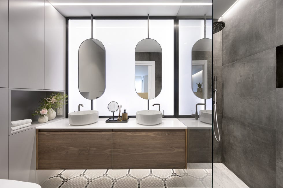 baño moderno con ducha a ras de suelo, mueble bajolavabo de madera suspendido y dos lavamanos