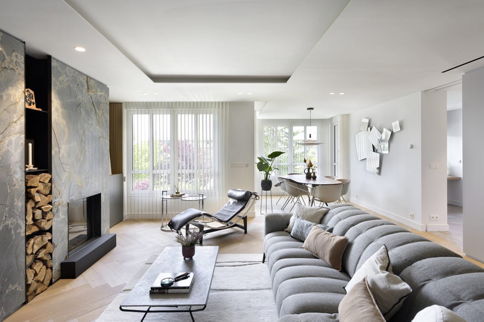 salón comedor con sofá gris con chaise longue y chimenea