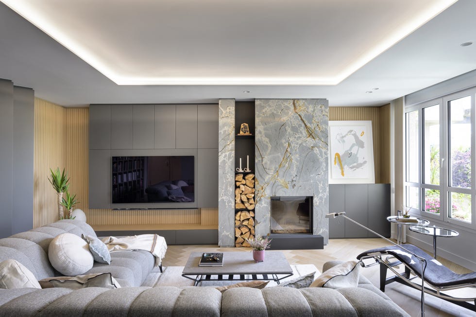 salón con sofá gris con chaise longue y chimenea