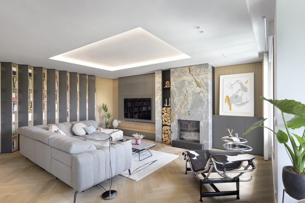salón moderno con sofá con chaise longue gris y biblioteca en zig zag