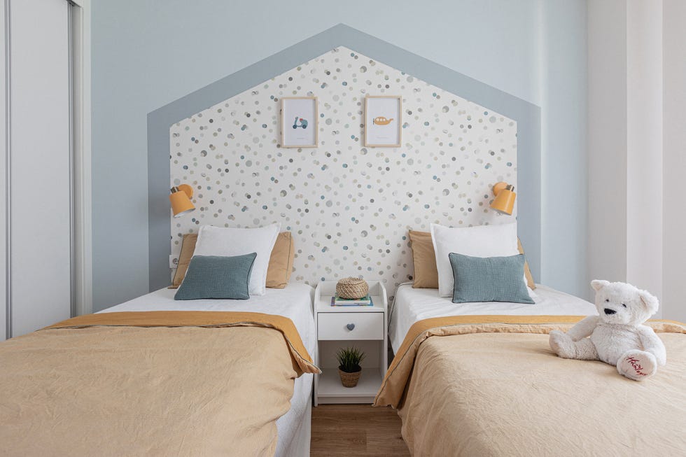dormitorio infantil con dos camas y papel pintado con forma de casita