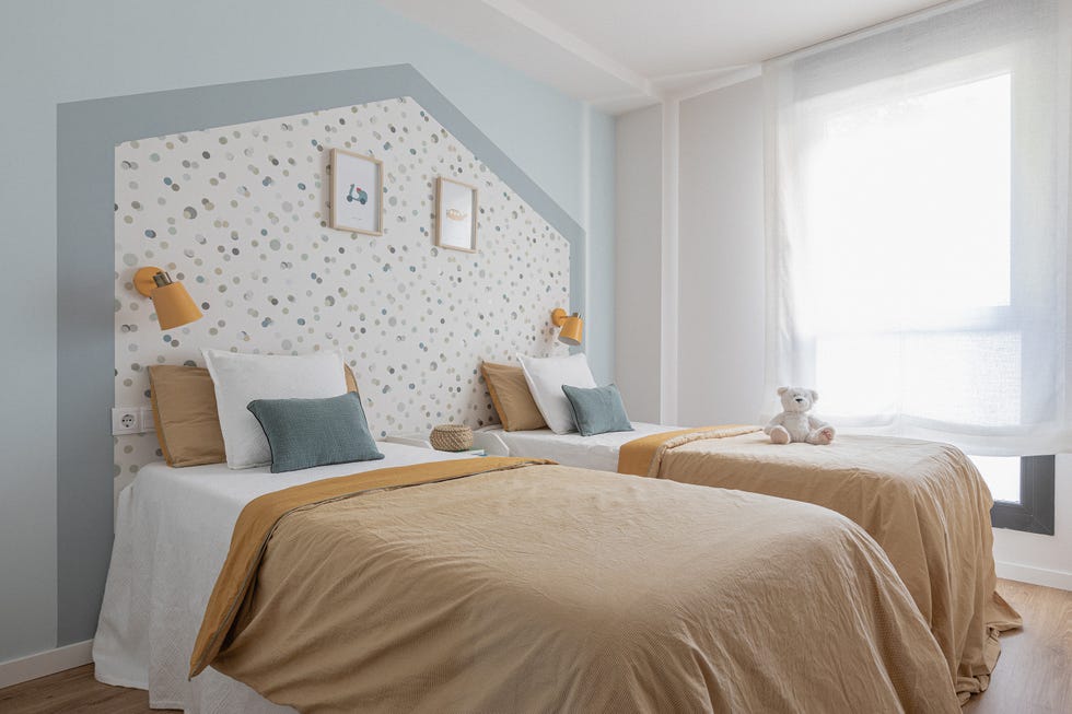 dormitorio infantil con dos camas y papel pintado con forma de casita