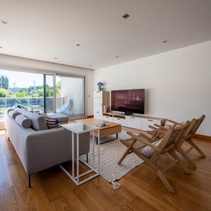salón decorado en tonos neutros con puertas correderas con acceso a la terraza