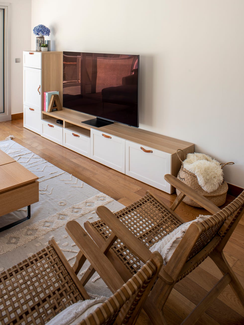 mueble de tv en madera con puertas blancas y tiradores de piel