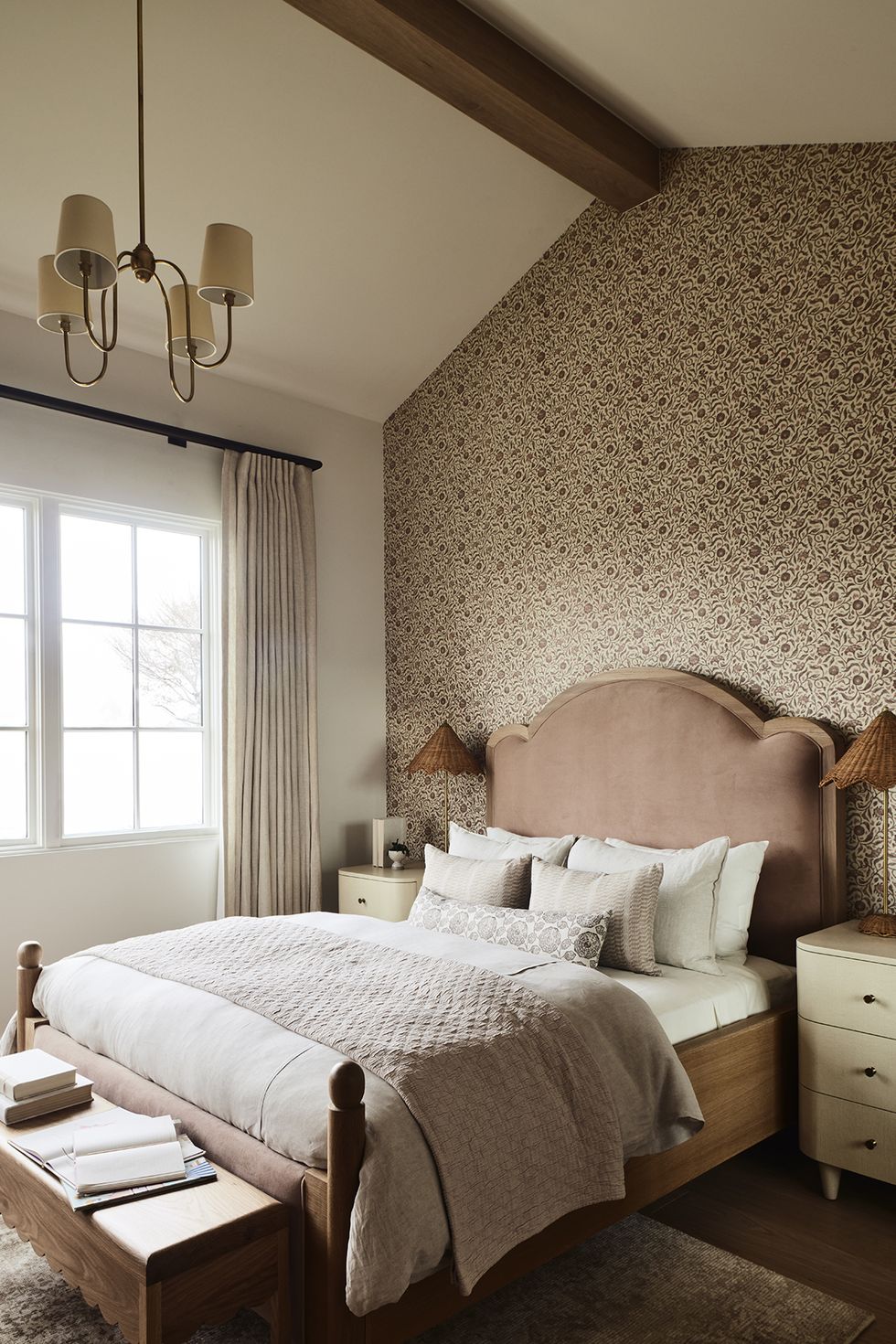 a bed with a large headboard and floral accent wall