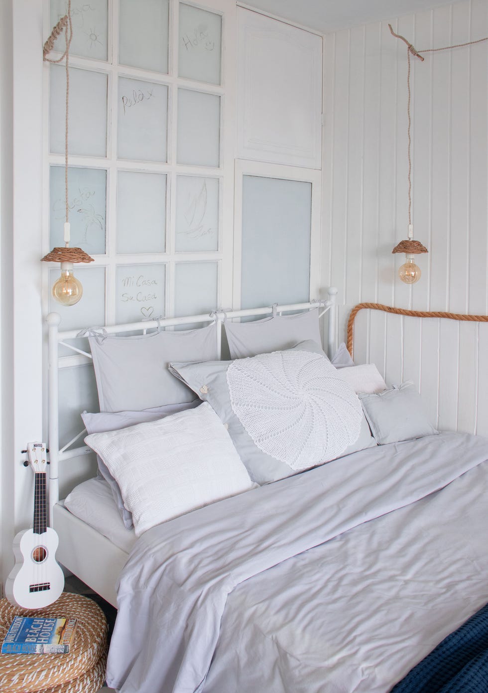 cama de forja blanca con lámparas colgantes