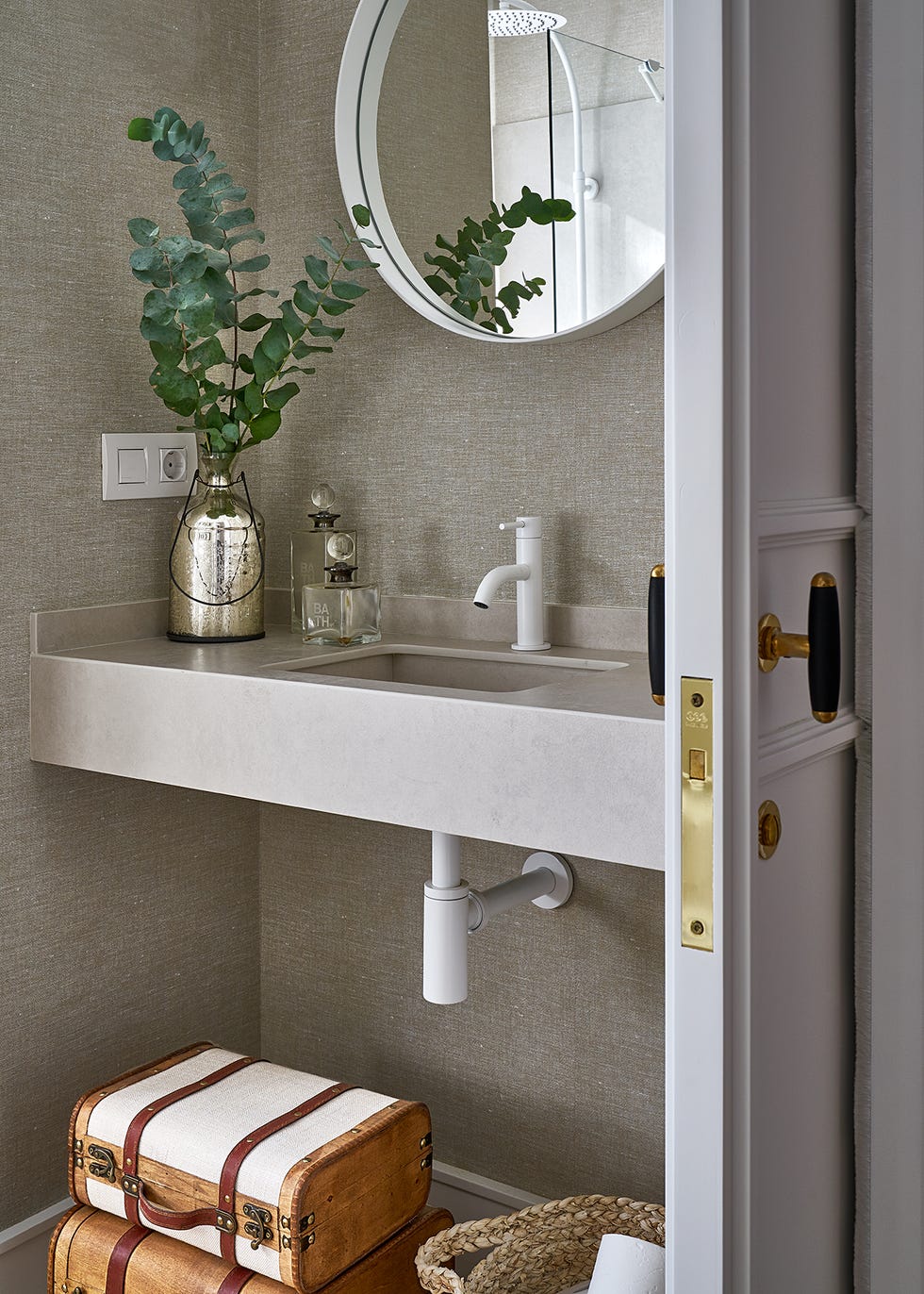 baño de invitados con lavabo gris volado y papel pintado con efecto tejido
