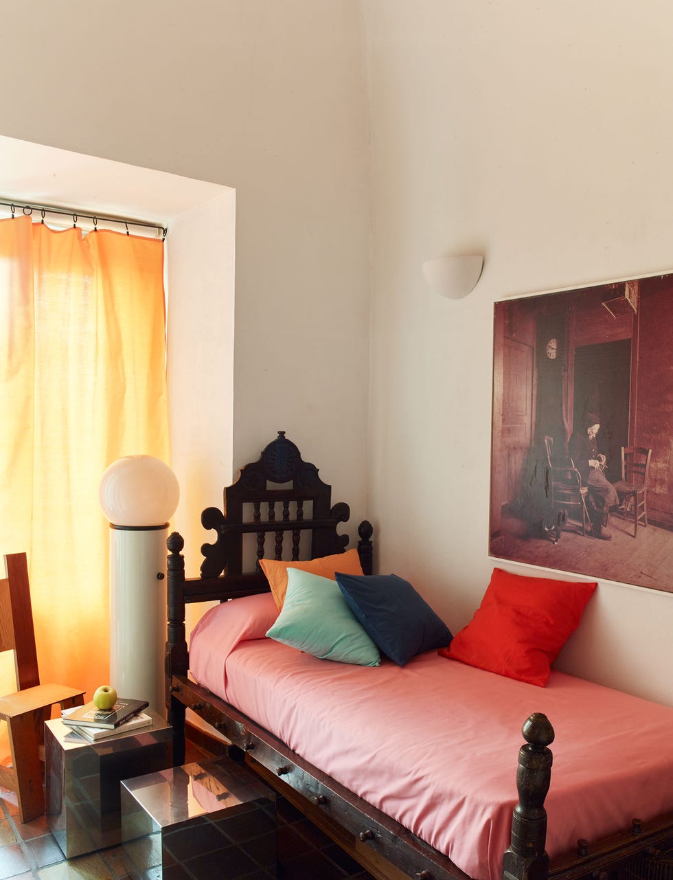 Casa Josephine Madrid Apartment madrid guest room with a twin bed dressed in bright linens and topped with cushions in different colors