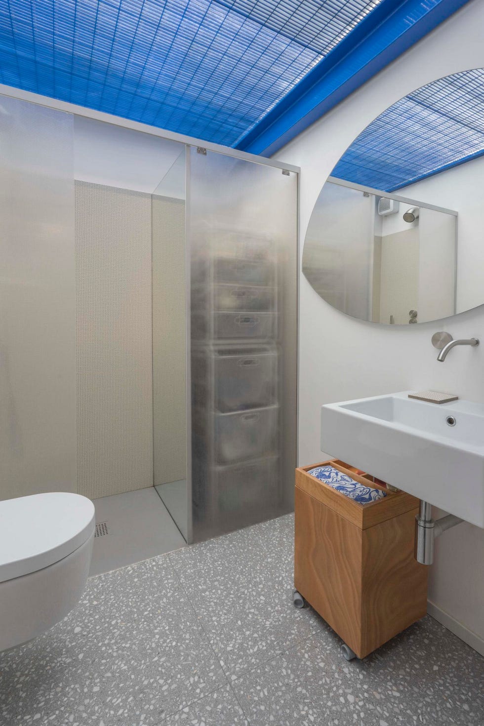 un baño interior se ilumina con una rejilla metálica que deja pasar la luz exterior