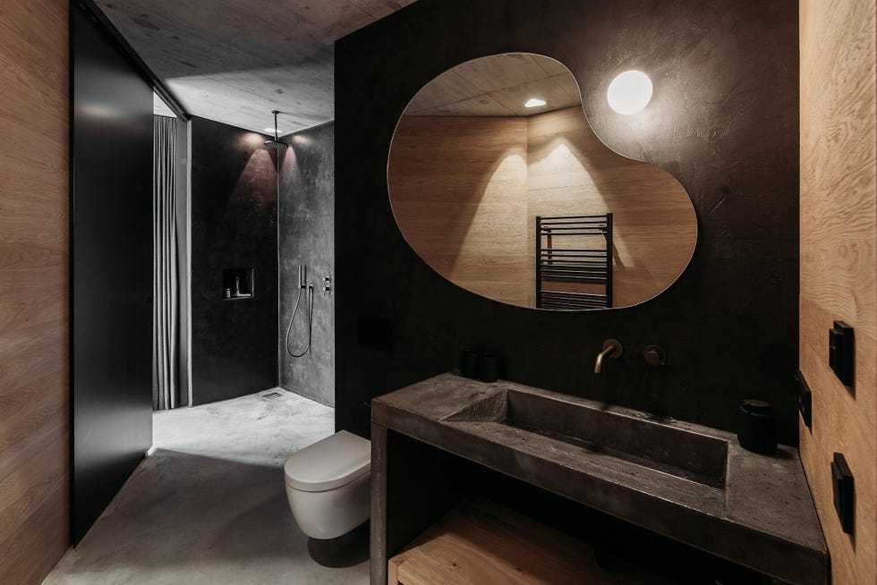 baño moderno diseñado en piedra y madera en tonos negros