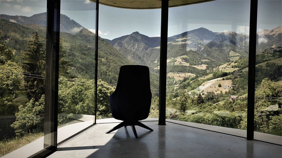 butaca frente a una galería acristalada con vistas a las montañas