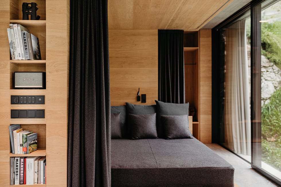 dormitorio con estructura de madera que integra la cama y la estantería
