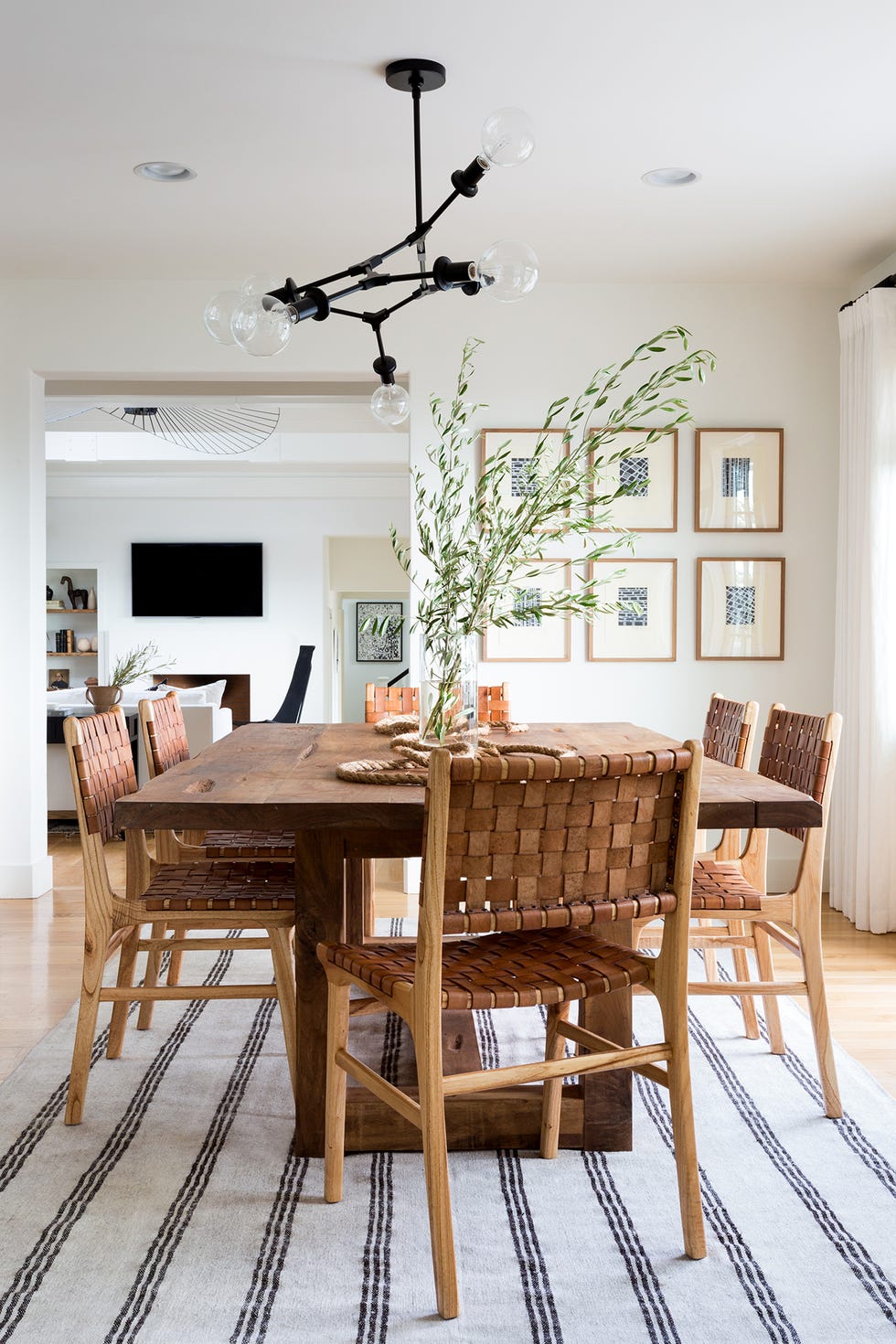 comedor con mesa de madera y sillas con asientos de cuero trenzado