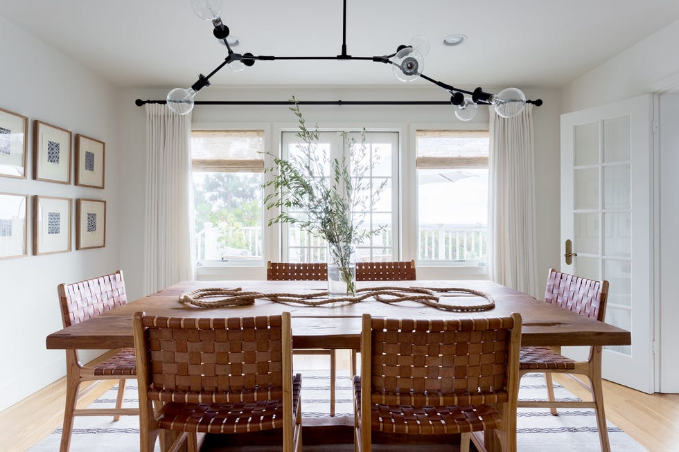 comedor con mesa de madera y sillas con asientos de cuero trenzado
