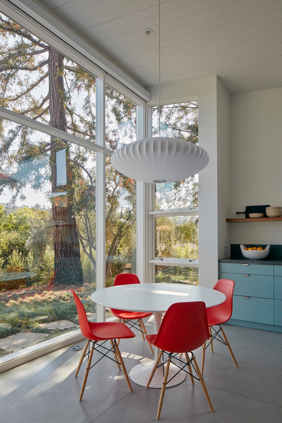 Office de diseño contemporáneo con mesa blanca y cuatro sillas rojas