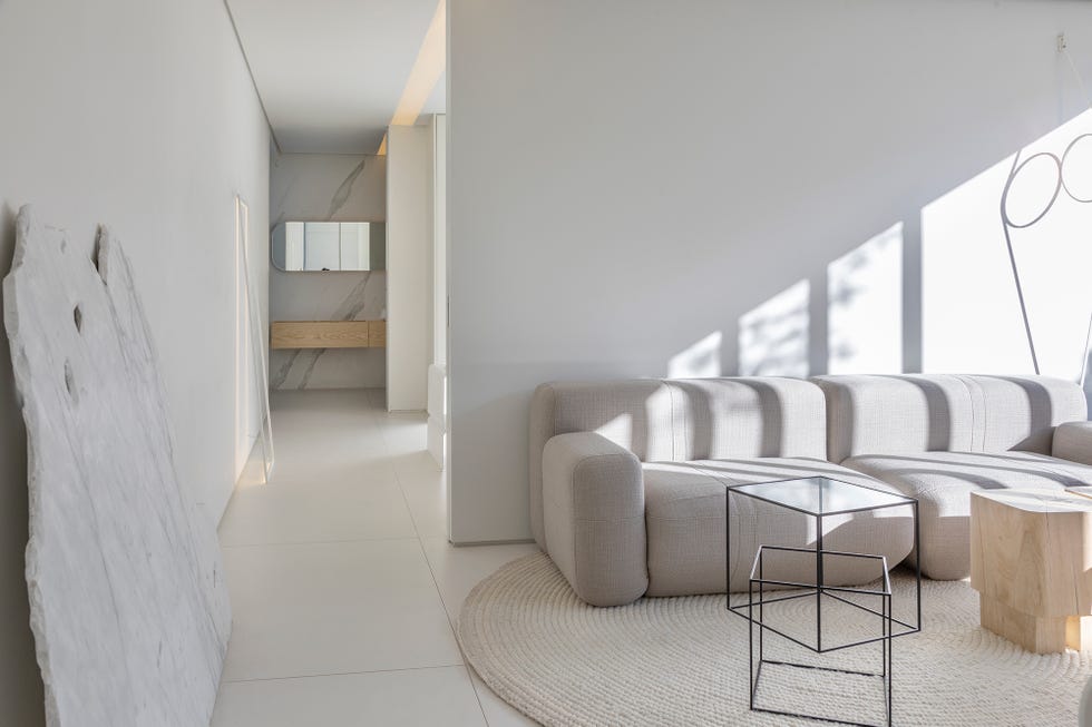 salón de diseño minimalista con sofá gris y mesas auxiliares de madera y metal
