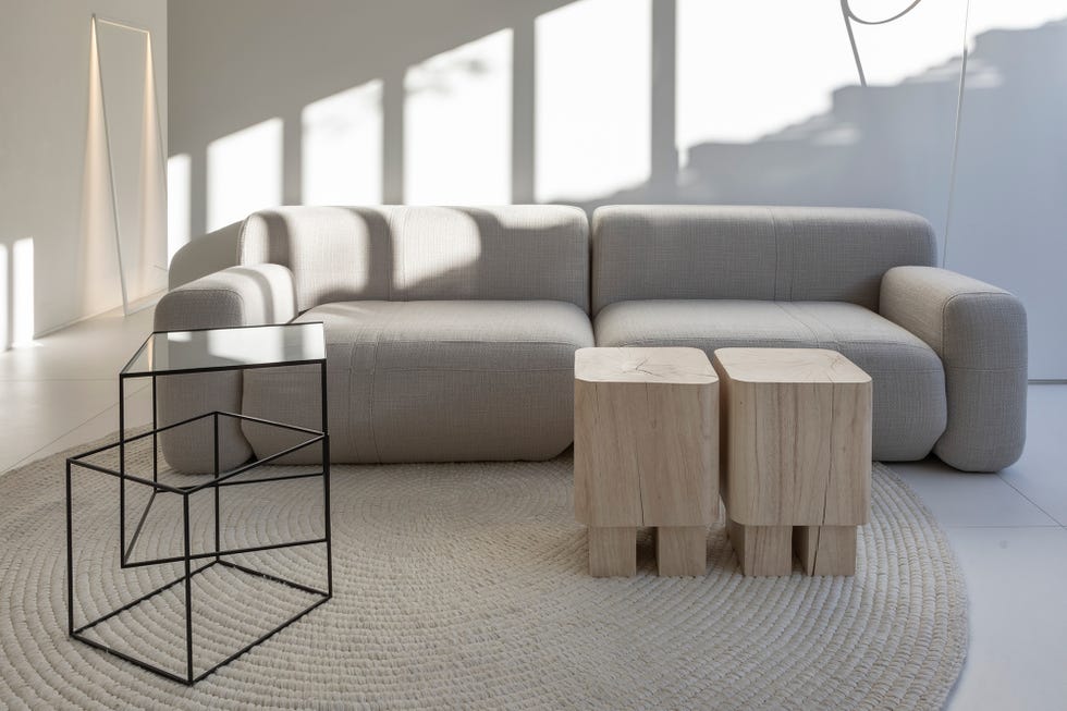 salón de diseño minimalista con sofá gris y mesas auxiliares de madera y metal