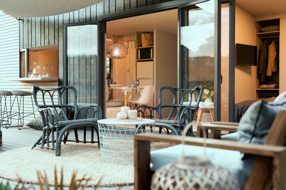 Terraza con zona de asientos conectada al salón con puertas correderas