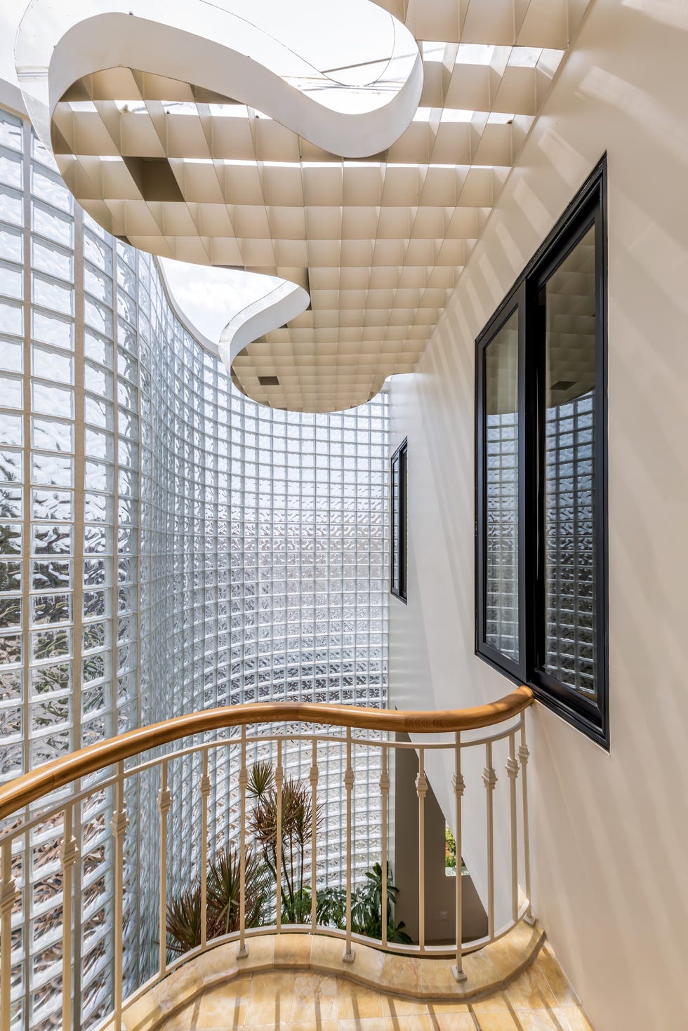 casa de 465 metros con fachada de ladrillo de vidrio, jardines interiores y soluciones pasivas