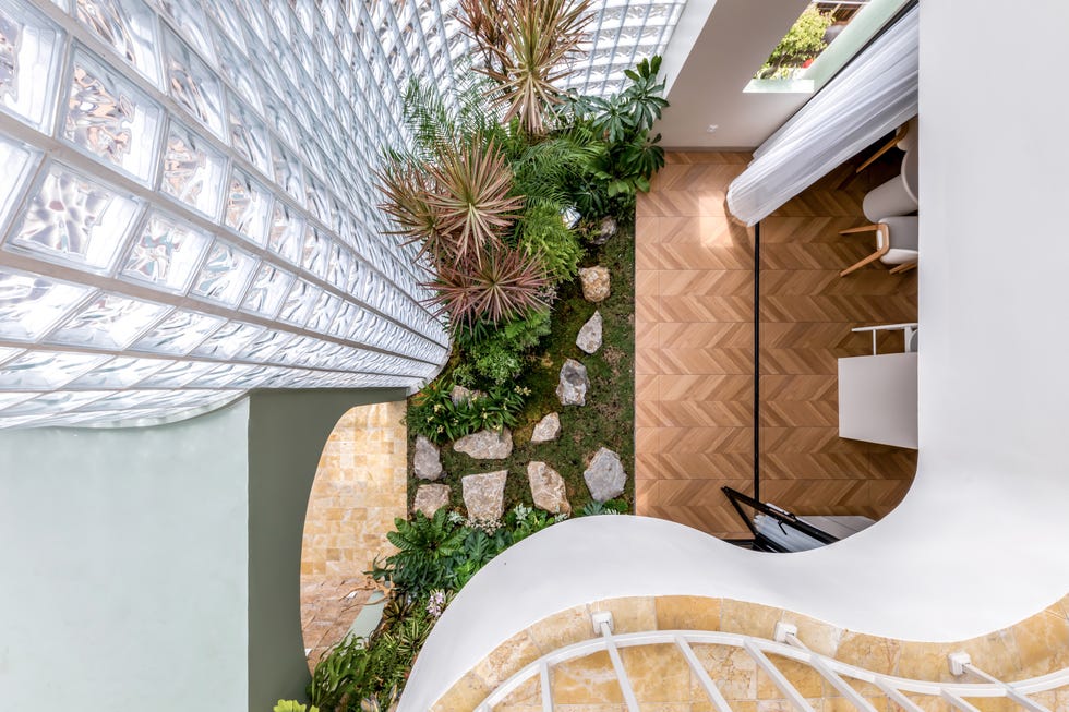 casa de 465 metros con fachada de ladrillo de vidrio, jardines interiores y soluciones pasivas