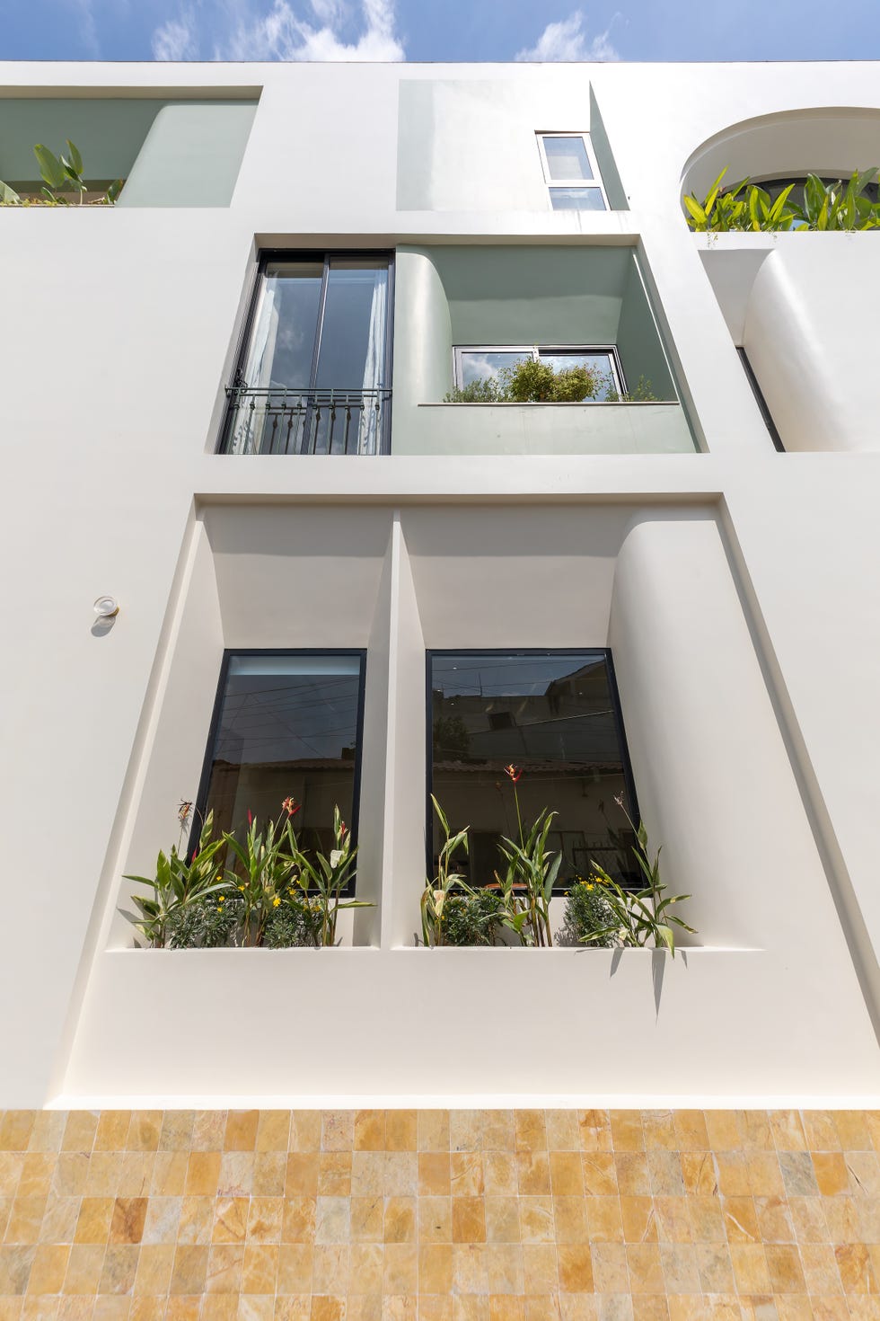 casa de 465 metros con fachada de ladrillo de vidrio, jardines interiores y soluciones pasivas