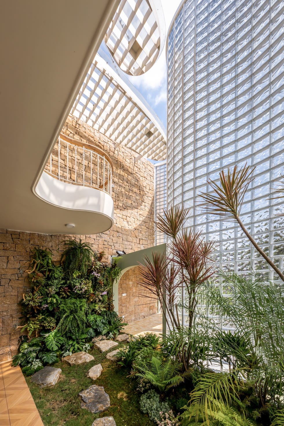 casa de 465 metros con fachada de ladrillo de vidrio, jardines interiores y soluciones pasivas