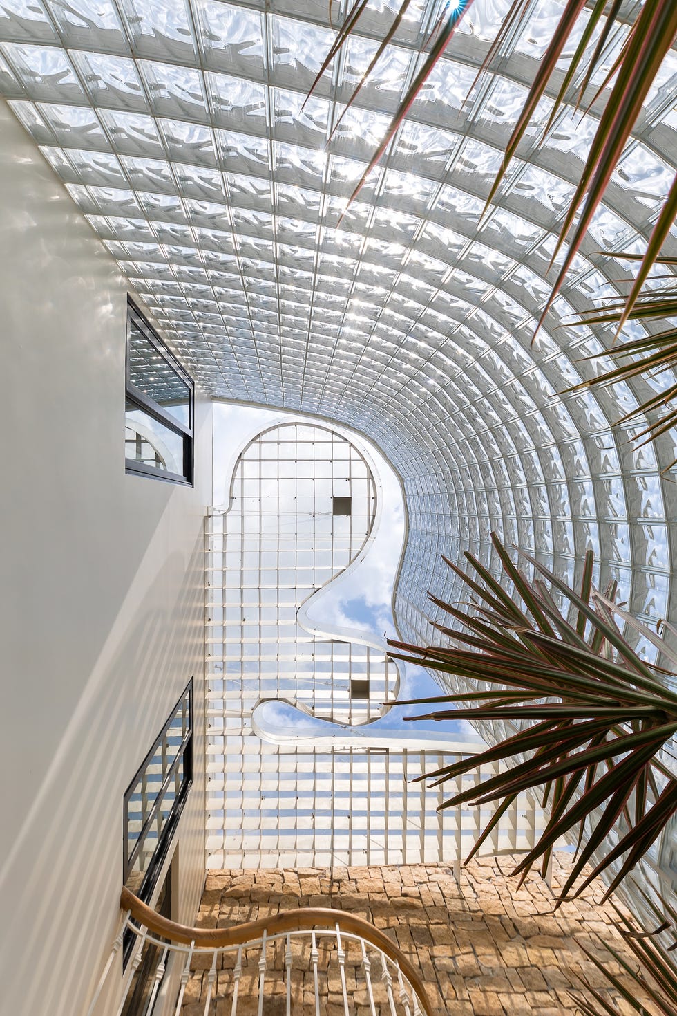 casa de 465 metros con fachada de ladrillo de vidrio, jardines interiores y soluciones pasivas