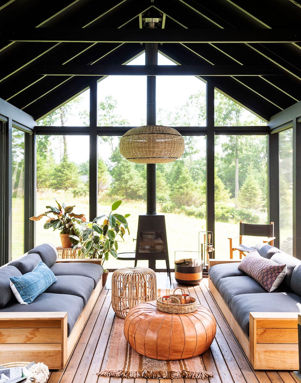 salón con dos sofás de madera rústicos y ventanales de suelo a techo