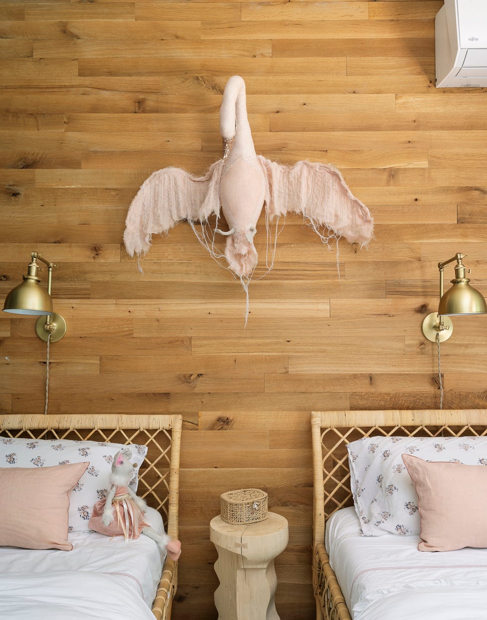 habitación infantil con pared de madera y dos camas de ratán