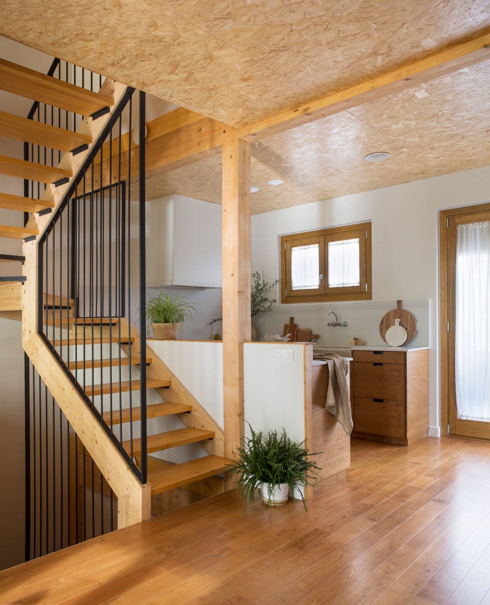 cocina abierta a la escalera revestida de madera