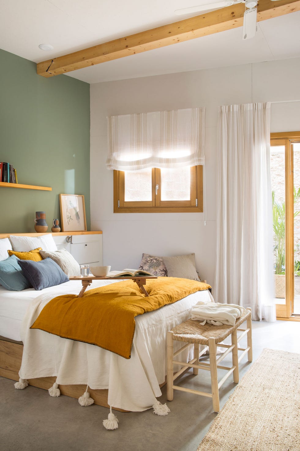 dormitorio con cabecero a medida, pared en color verde y banco de fibras al pie de cama