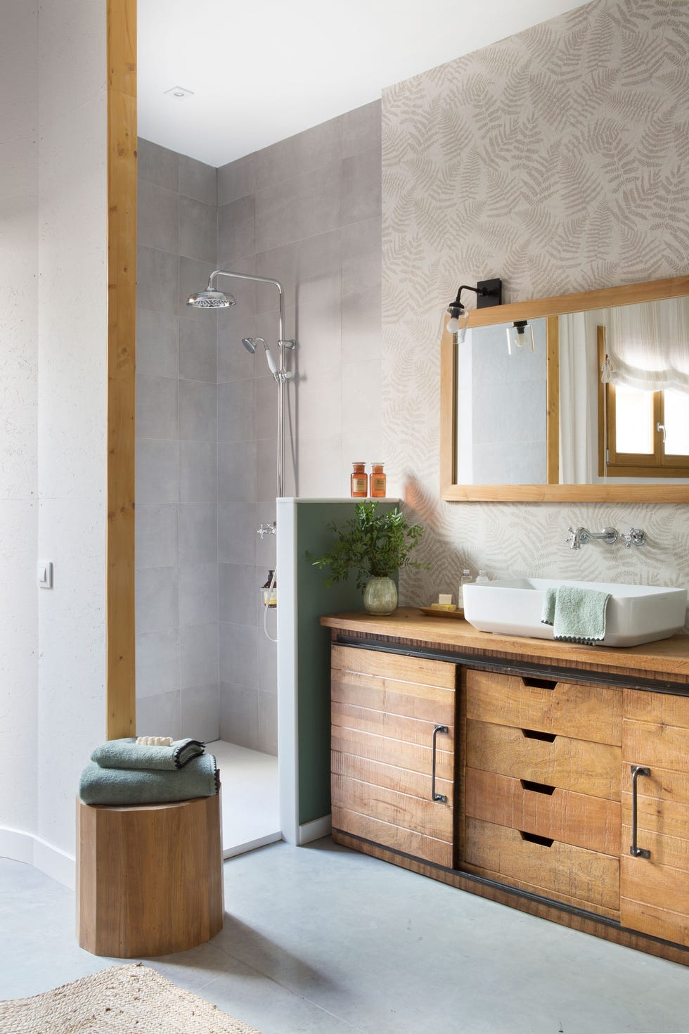 baño con mueble bajolavabo de madera y papel pintado con motivos botánicos