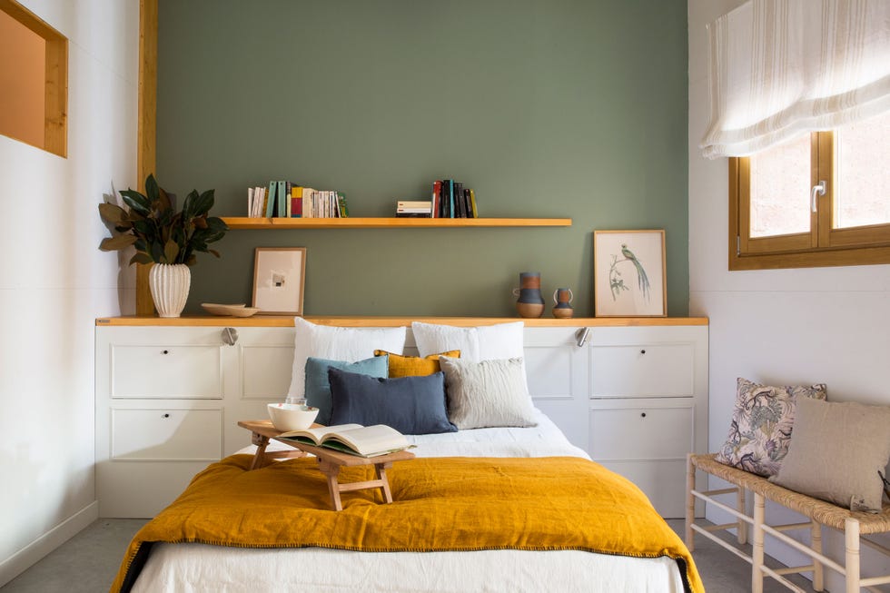 dormitorio con cabecero a medida, pared en color verde y banco de fibras al pie de cama